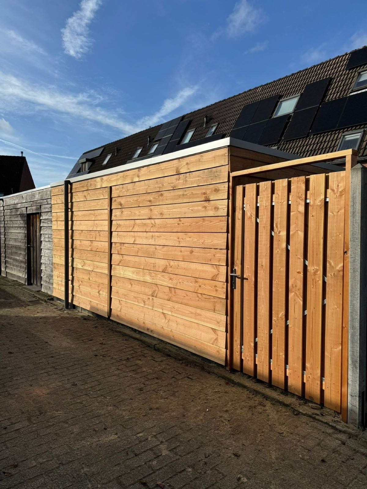 Moderne houten schutting met poort op maat geplaatst door BijHof